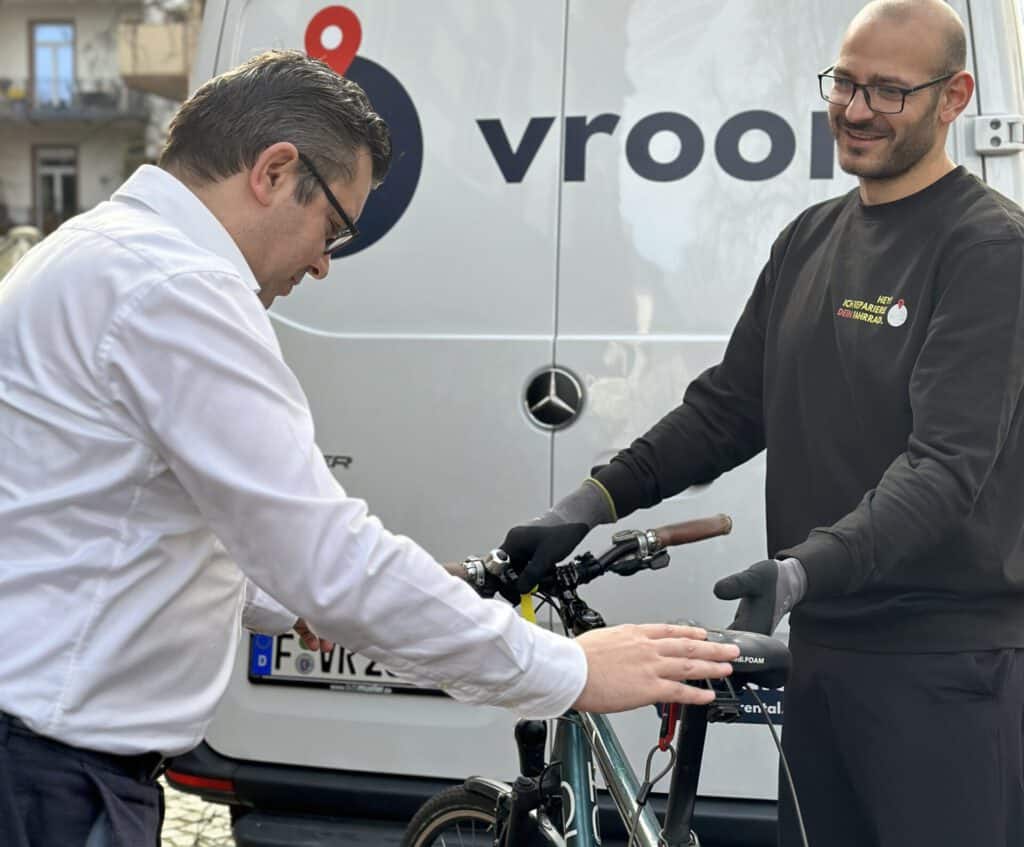 VROOM REPAIR Lieferfahrer der Fahrradreparatur übergibt fertiges Fahrrad